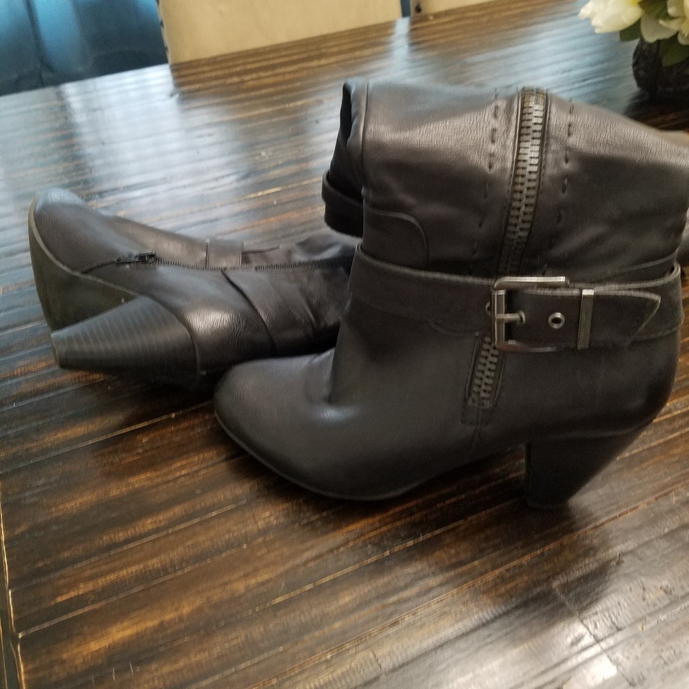 Black boots with stitching on the side and buckle.